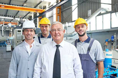 Factory owner on shop floor with 3 employees.