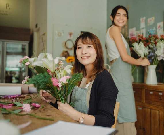 Two young women working in a flower shop.