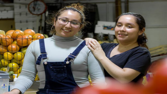 Pic of mother and daughter family business owners posing in their store