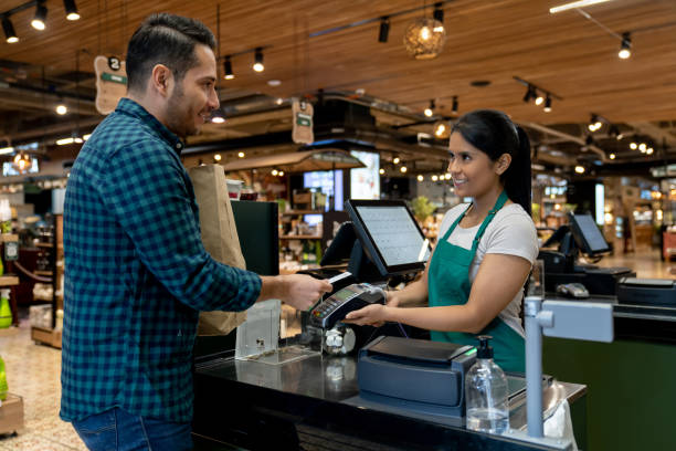 Pic of Latin American man making a contactless payment at the supermarket using his credit card