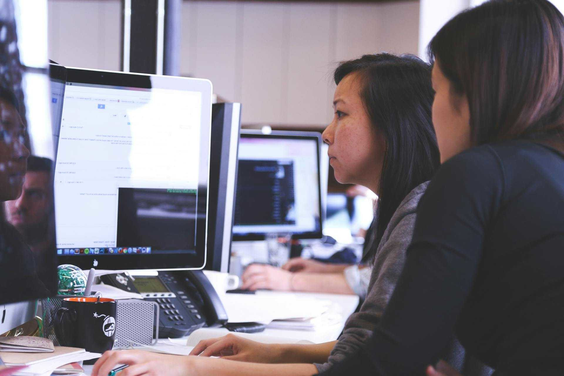 Image of 2 female SEO specialists working together in a busy Digital Marketing Agency.